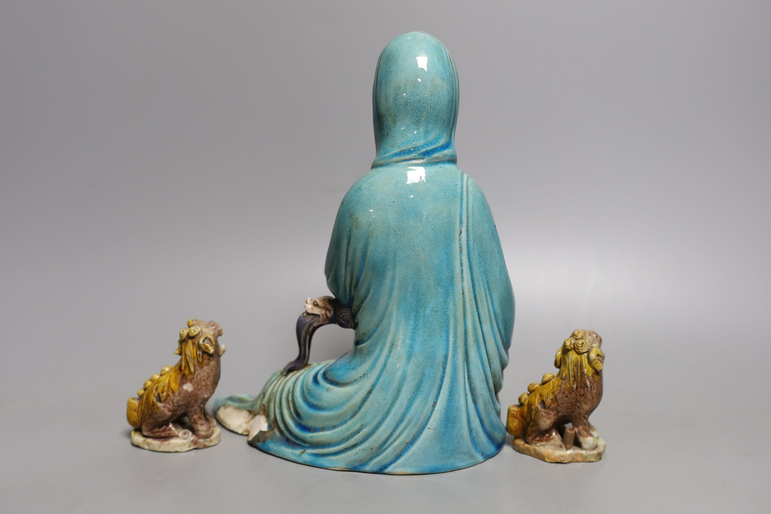 An early 20th century Chinese polychrome porcelain figure of Guanyin, 21cm tall, and two dogs
